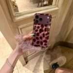 Purple Leopard Star iPhone Case with charm strap, held in hand
