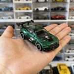 Green GT3 race car diecast on palm for size